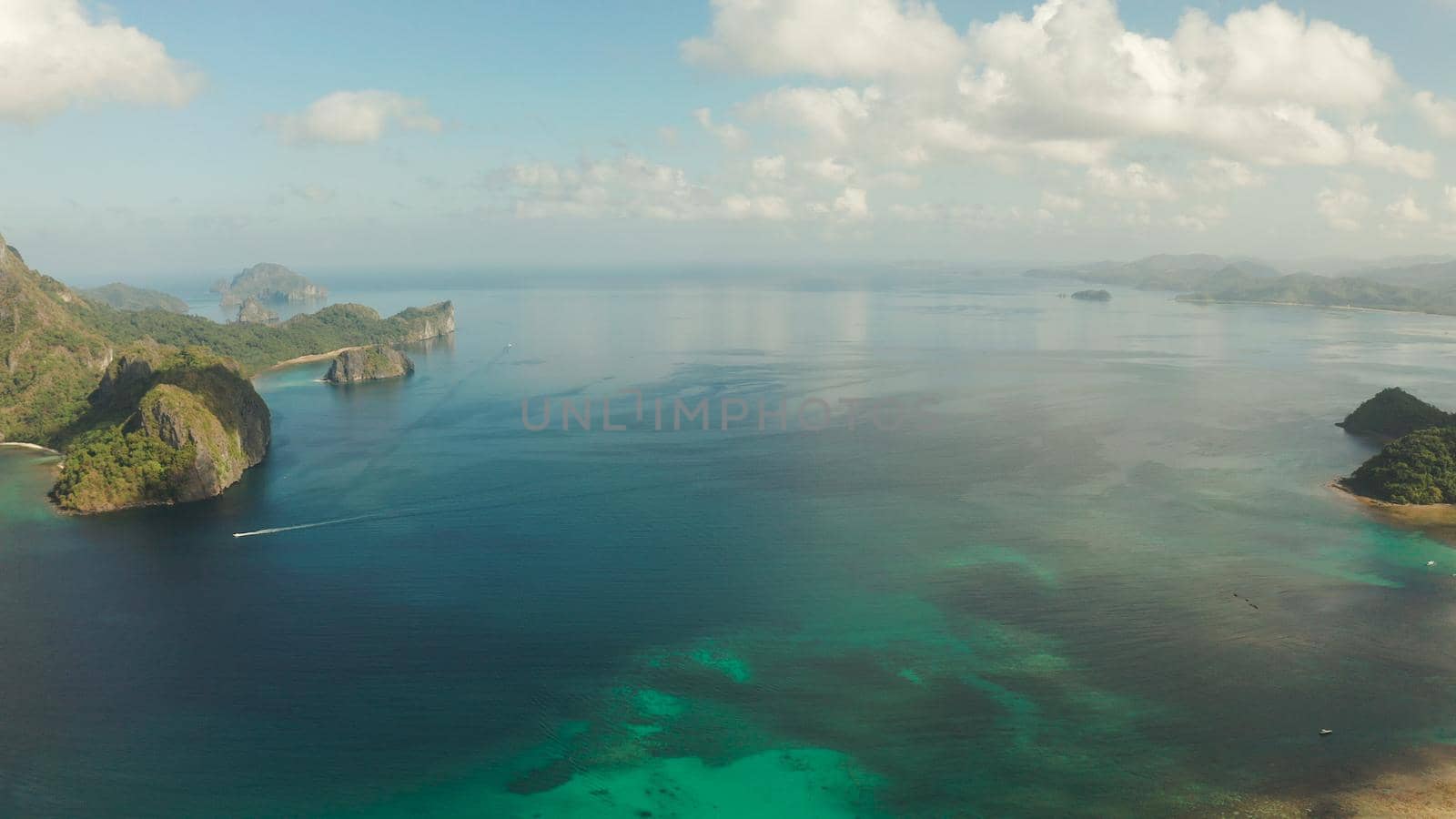 Cove with tropical rocky islands covered with rainforest, sea with blue water, aerial view. El nido, Philippines, Palawan. Tropical Mountain Range