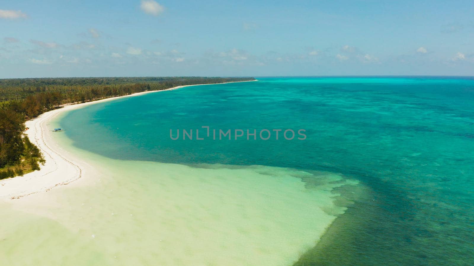 Tropical island with sandy beach by atoll with coral reef and blue sea, aerial view. Bugsuk Island with sandy beach. Summer and travel vacation concept.