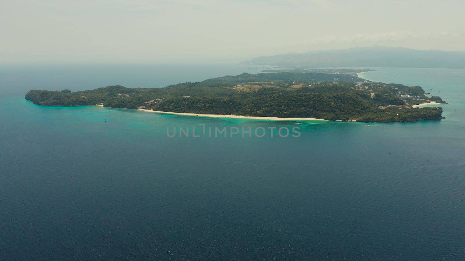 Tropical island Boracay with sandy beach and hotels view from the sea, aerial view. Summer and travel vacation concept. Philippines