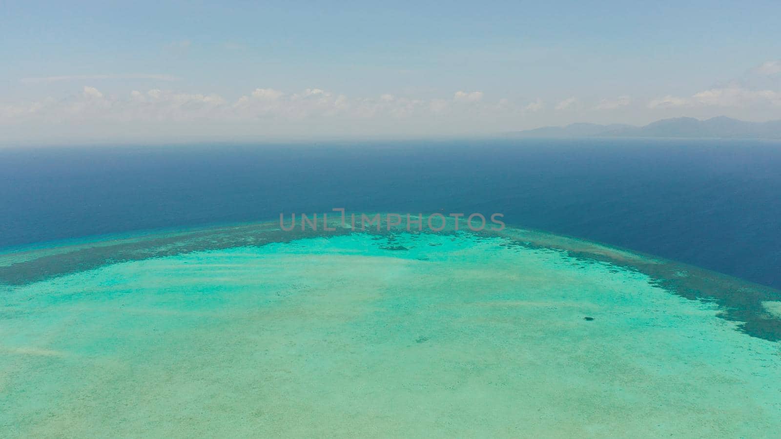 Tropical coral atoll with turquoise water against the sky with clouds top view. Summer and travel vacation concept. Balabac, Palawan, Philippines