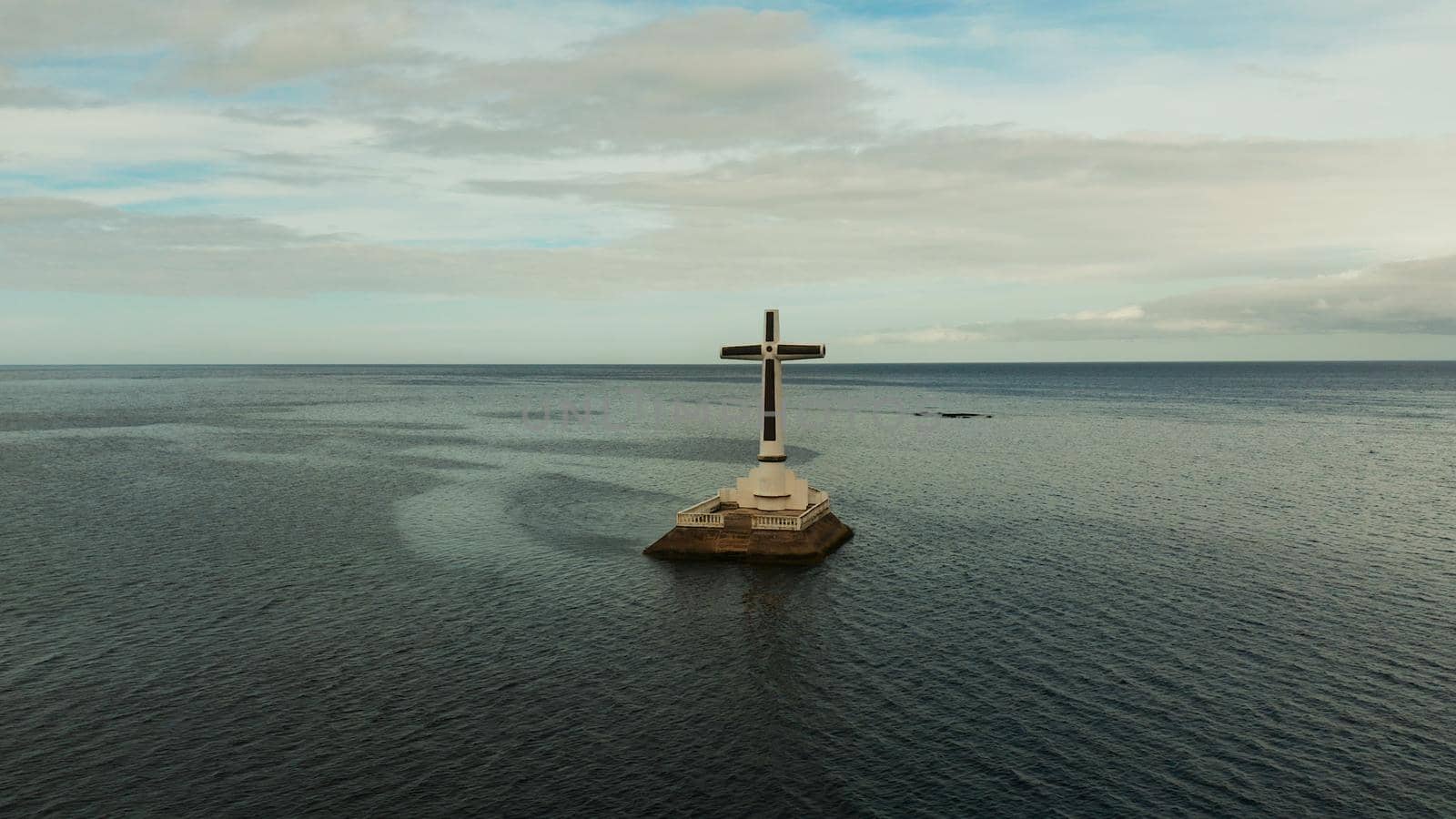 Catholic cross in sunken cemetery in the sea at sunset, aerial view. Sunset at Sunken Cemetery Camiguin Island Philippines.