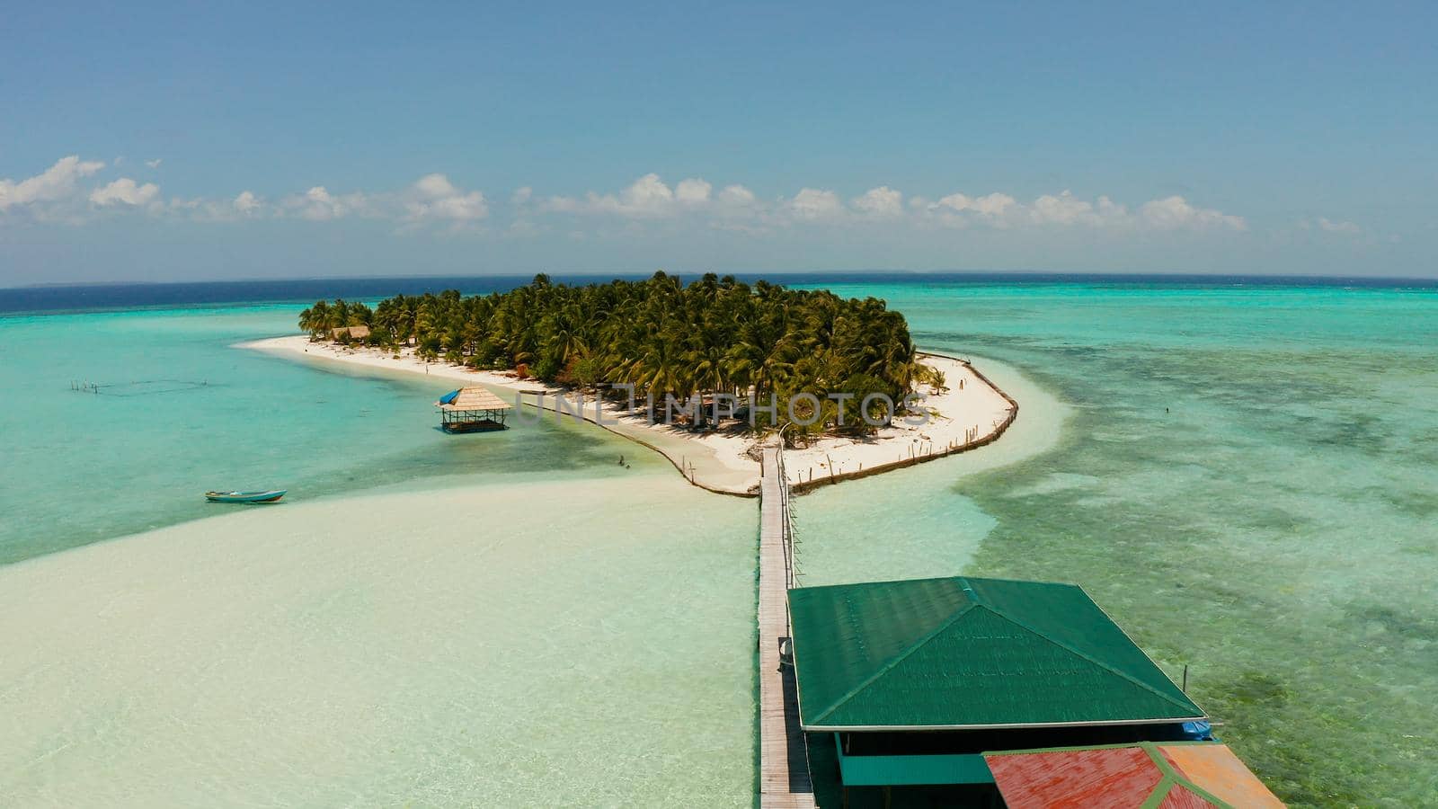 Seascape with beautiful beach and tropical island surrounded by a coral reef from above. Onok Island, Balabac, Philippines. Summer and travel vacation concept