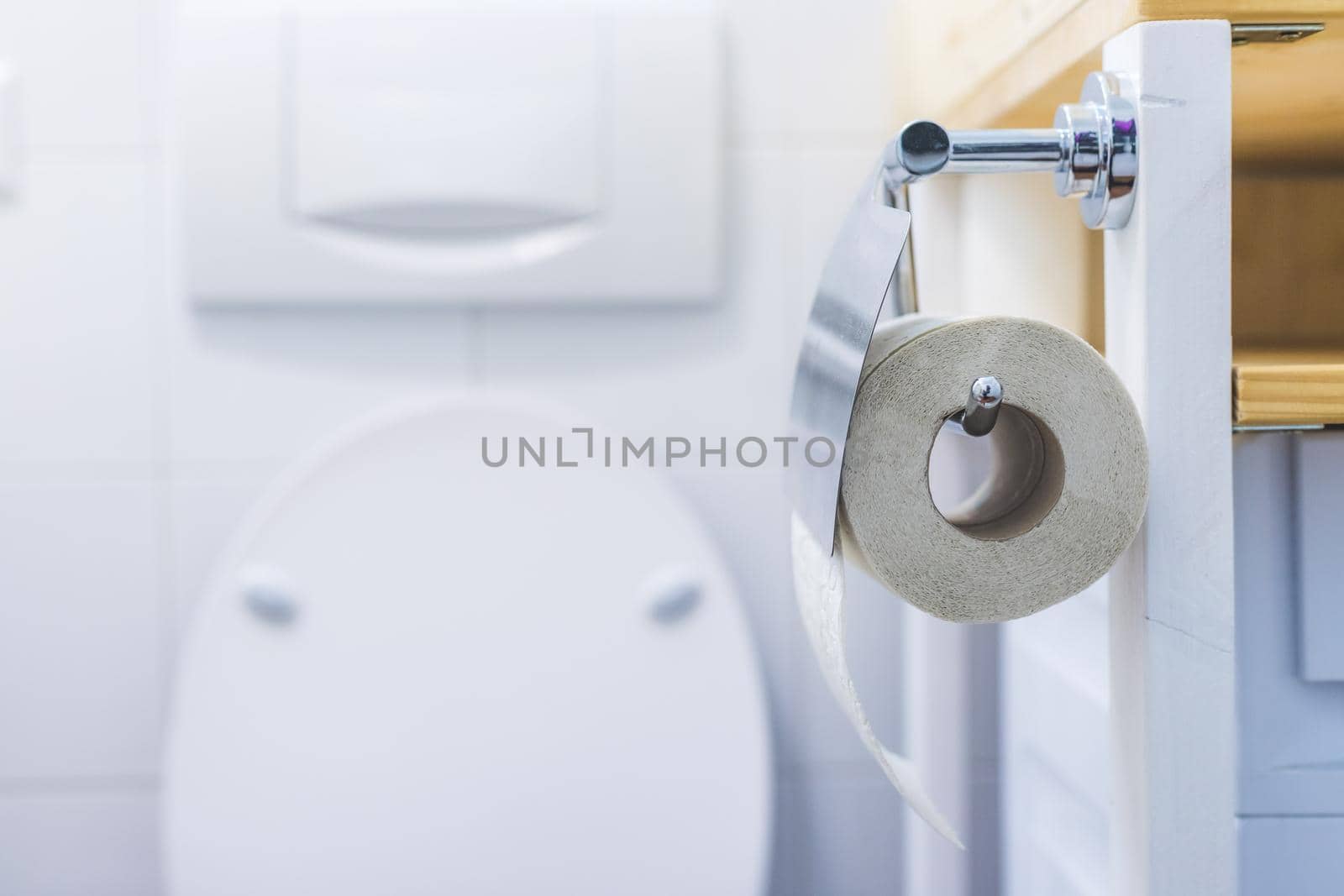 Close up of toilet paper roll on chrome hanger