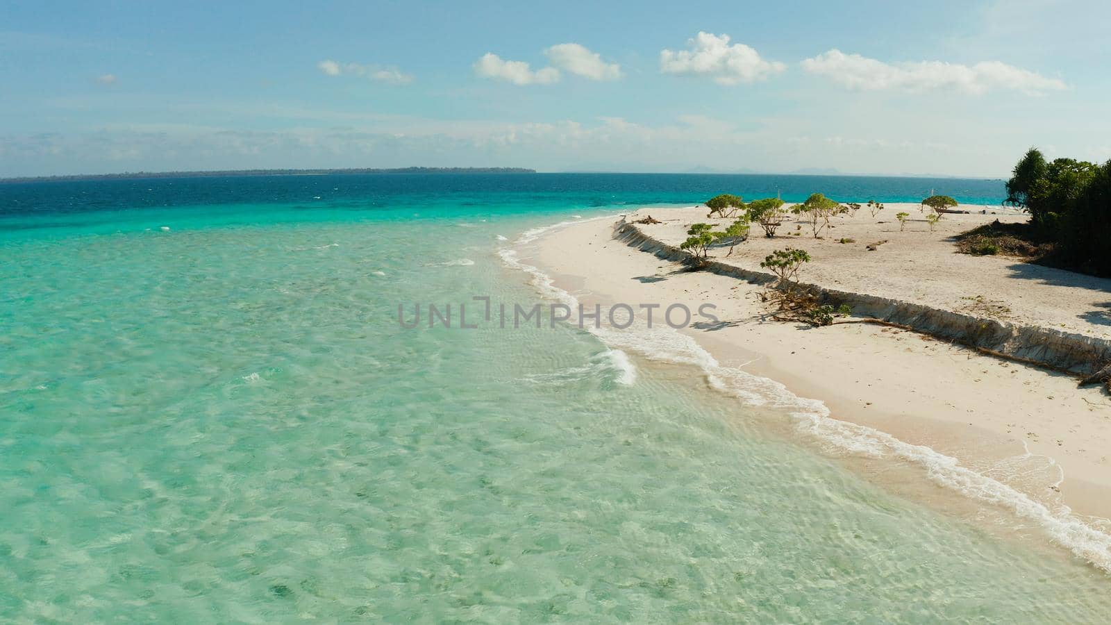 Sandy beach and turquoise water in the blue lagoon, aerial view. Patawan island with sandy beach. Summer and travel vacation concept.