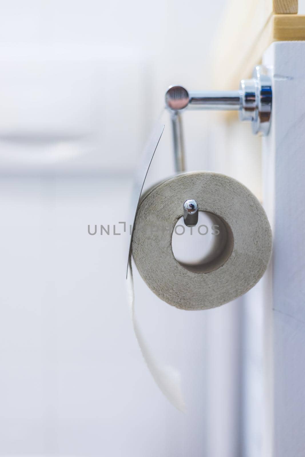 Close up of toilet paper roll on chrome hanger