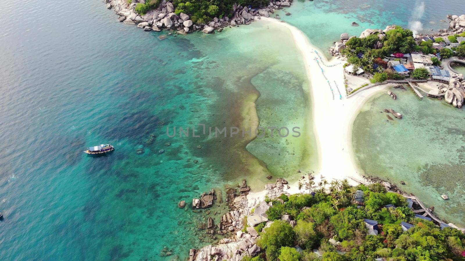 Calm colorful azure turquoise sea near tiny tropical volcanic island Koh Tao, unique small paradise Nang Yuan. Drone view of peaceful water near stony shore and green jungle on sunny day in Thailand