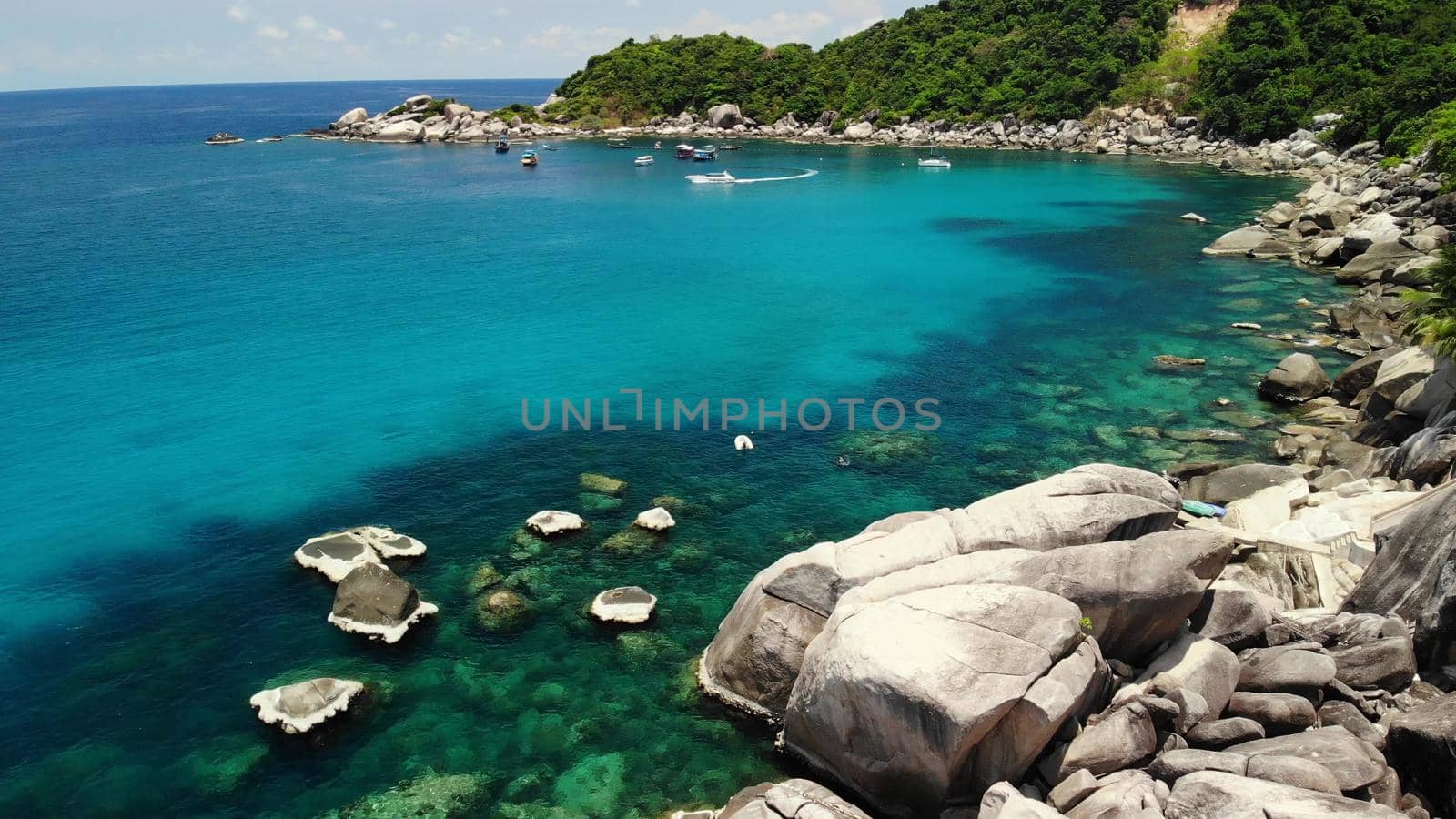 Tourist boats in tropical bay. Drone view of tourist boats with divers and snorkelers floating on calm sea water in Hin Wong Bay of tropical volcanic Koh Tao Island in Thailand