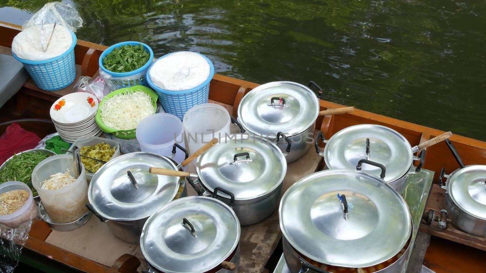 Iconic asian Lat Mayom floating market. Khlong river canal, long-tail boat with bowls of traditional thai cusine streetfood. Top view of siamese spicy street food assortment in wooden canoe for sale by DogoraSun