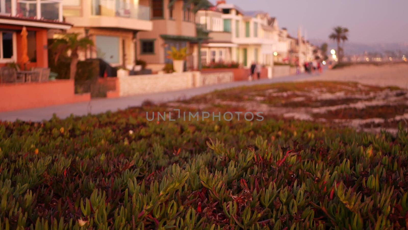 California summertime dusk beach aesthetic, pink sunset over beachfront weekend houses. Blurred defocused people walking, seafront promenade in Newport, pacific ocean resort near Los Angeles CA USA by DogoraSun