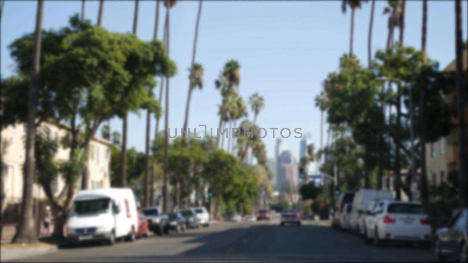 Driving on downtown streets of Los Angeles, California USA. Defocused view from car thru glass windshield on driveway. Blurred road with vehicles in Hollywood. Camera inside auto, LA city aesthetic.