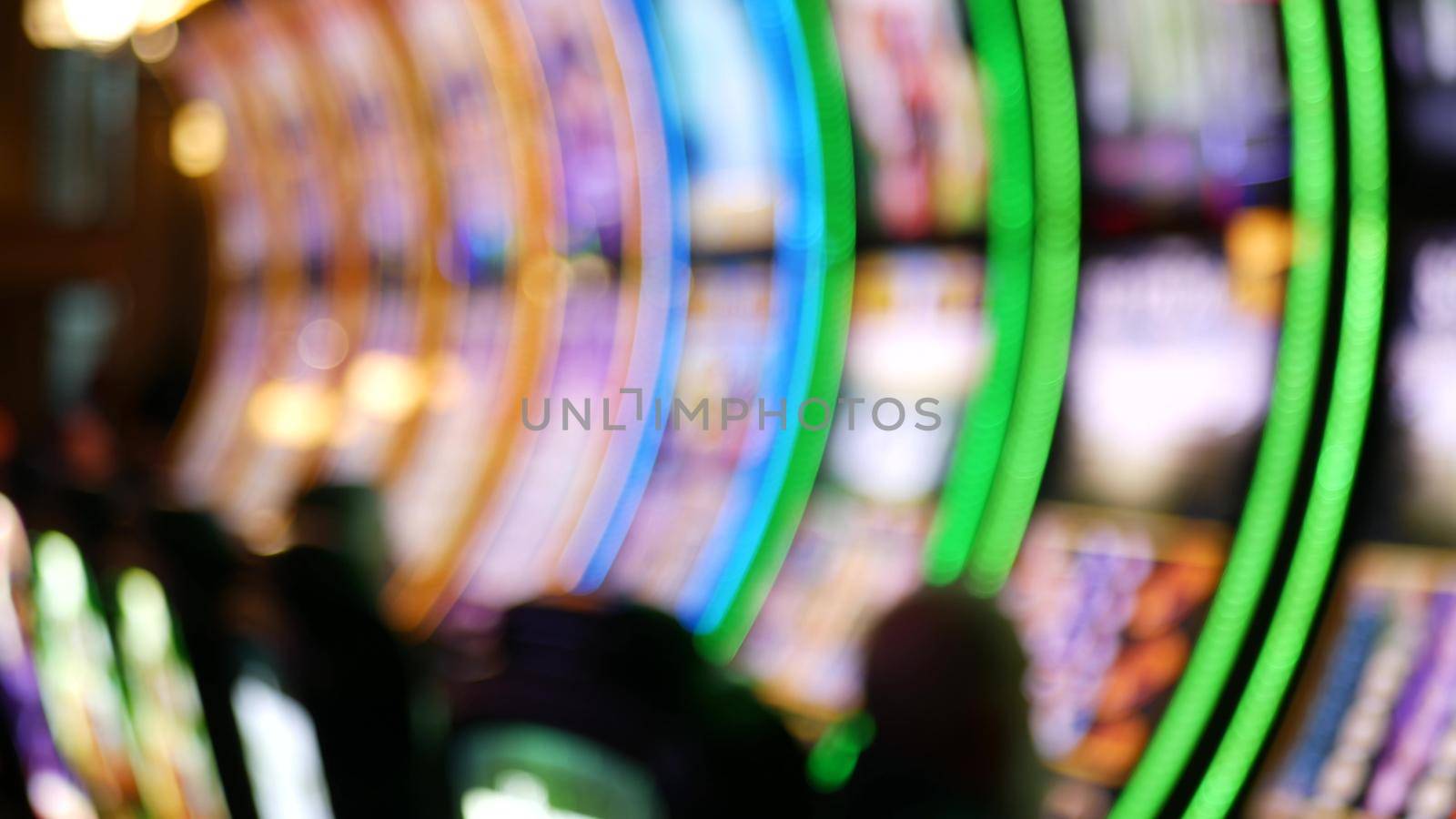 Defocused slot machines glow in casino on fabulous Las Vegas Strip, USA. Blurred gambling jackpot slots in hotel near Fremont street. Illuminated neon fruit machine for risk money playing and betting.