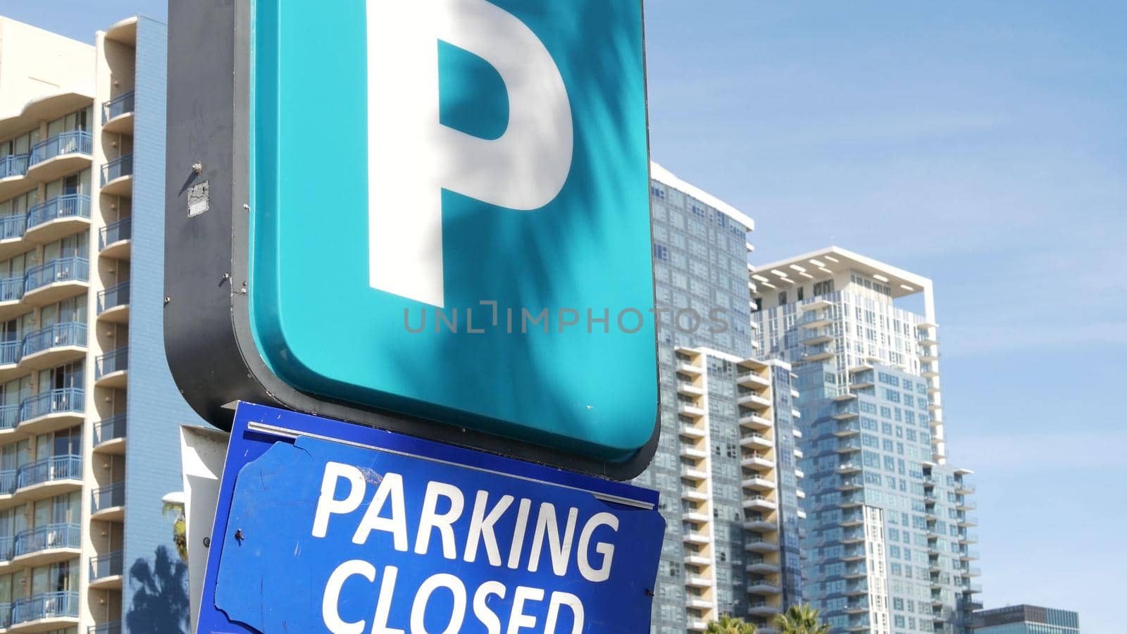 Parking lot sign as symbol of traffic difficulties and transportation issues in busy urban areas of USA. Public paid parking zone in downtown of San Diego, California. Limited space for cars in city by DogoraSun