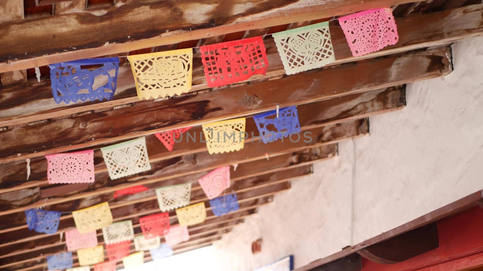 Colorful mexican perforated papel picado banner, festival colourful paper garland. Multi colored hispanic folk carved tissue flags, holiday or carnival. Authentic fiesta decoration in Latin America.