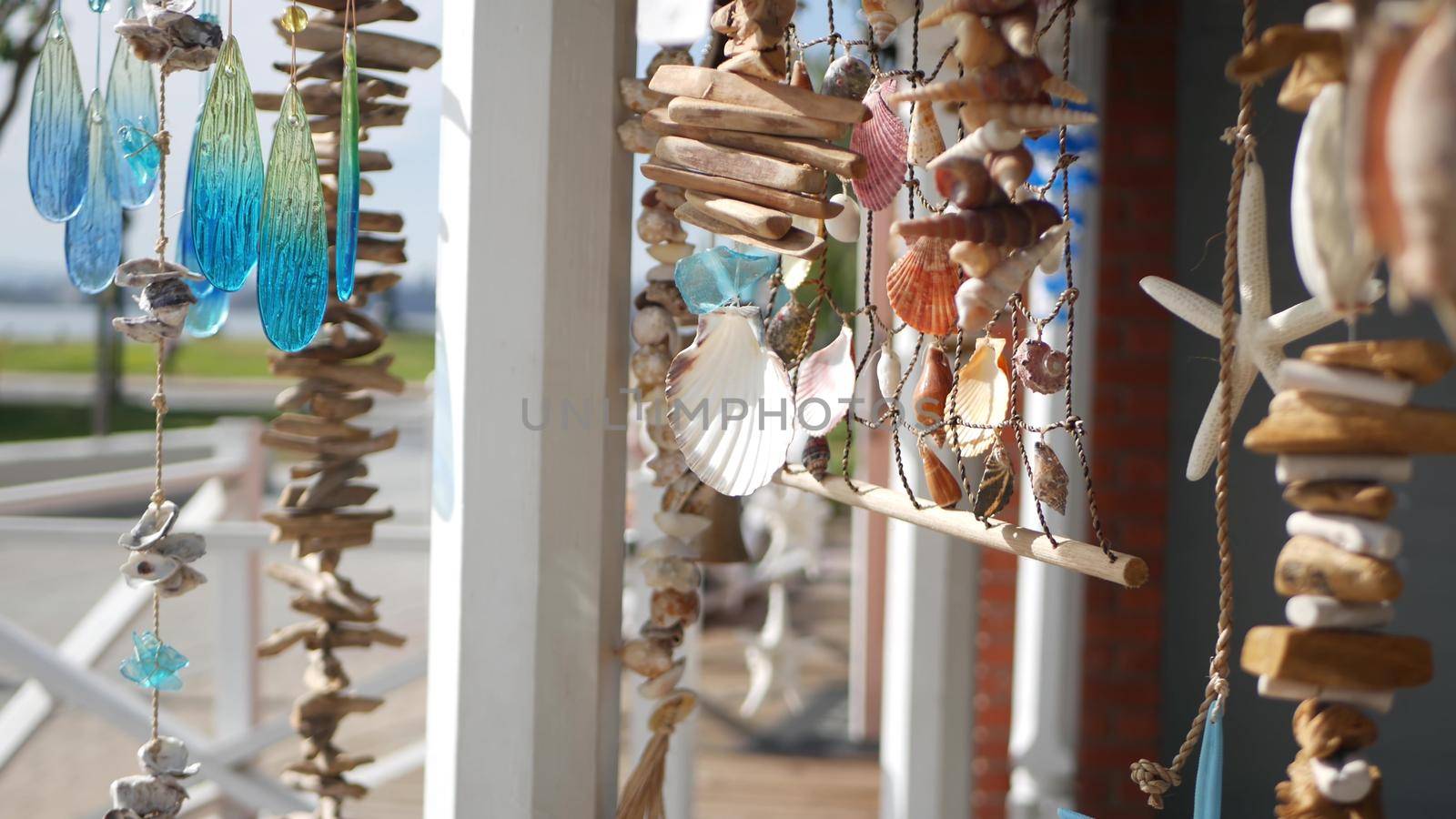 Nautical style hanging seashells decoration, beachfront blue wooden holiday home, pacific coast, California USA. Marine pastel interior decor of beach house in breeze. Summertime sea wind aesthetic.