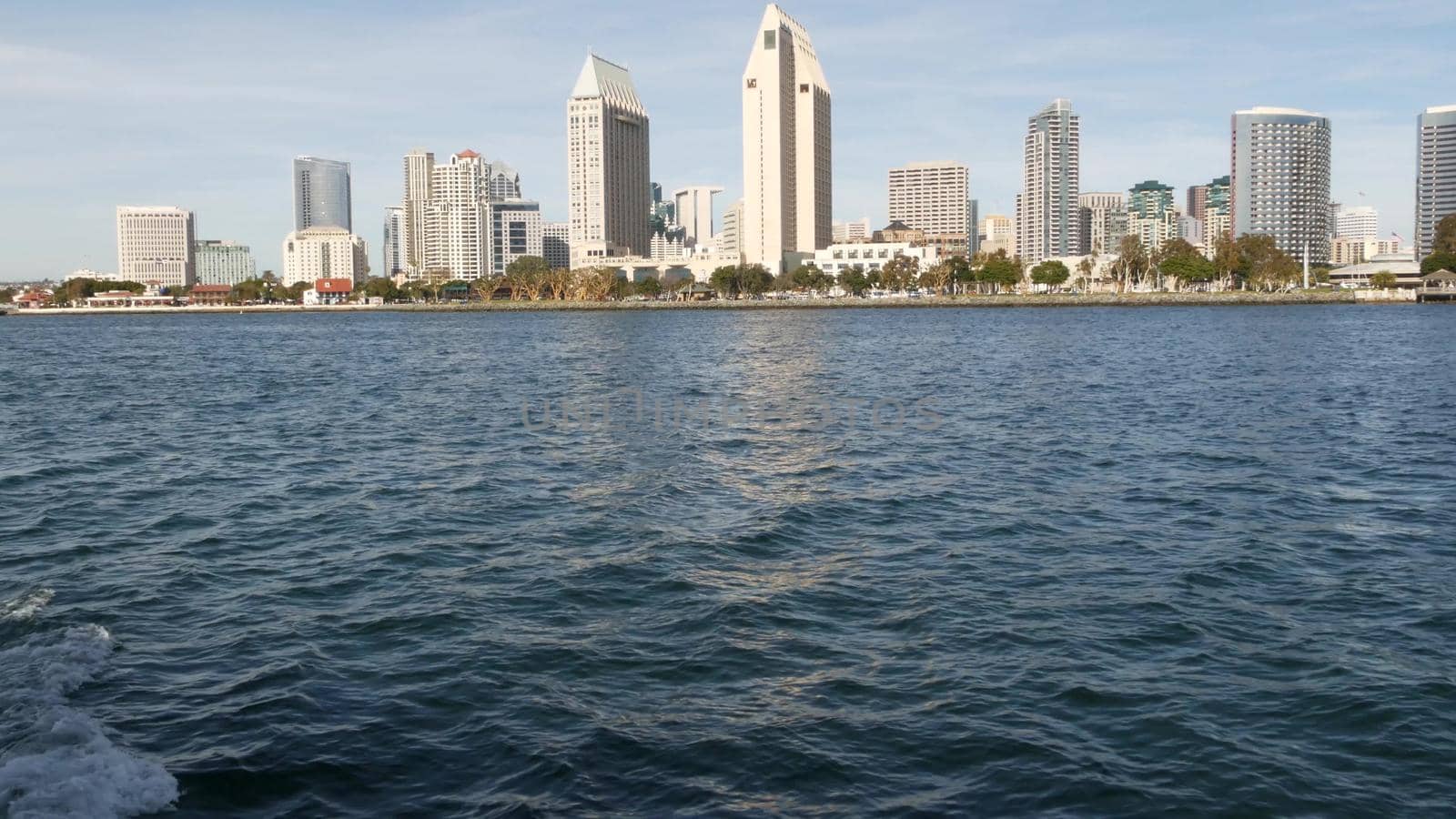 Metropolis urban skyline, highrise skyscrapers of city downtown, San Diego Bay, California USA. Waterfront buildings near pacific ocean harbour. View from boat, nautical public transport to Coronado by DogoraSun
