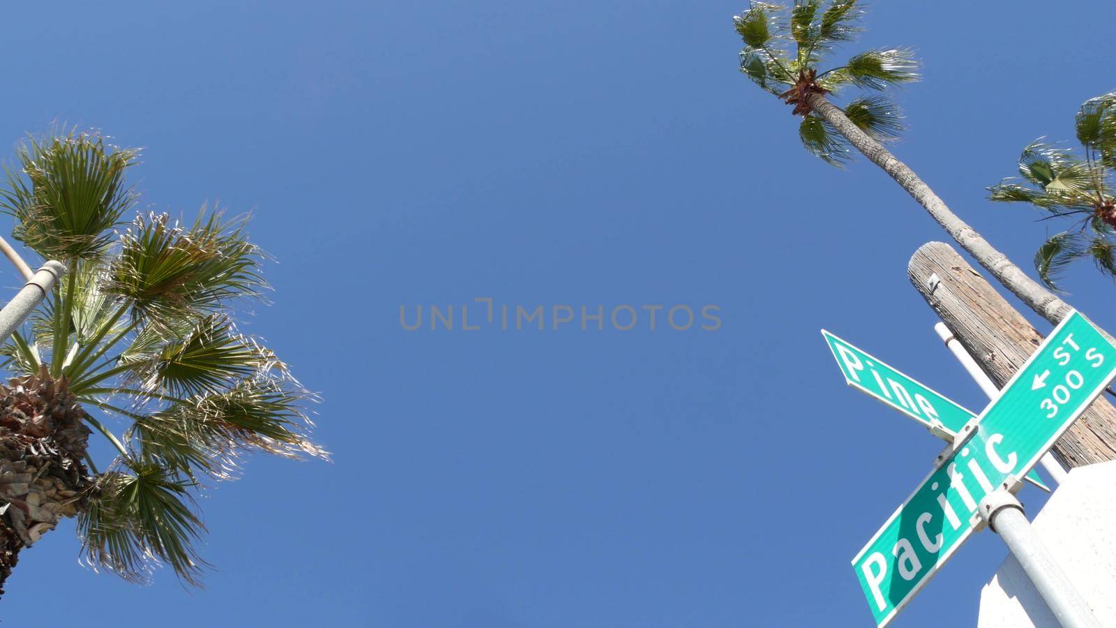 Pacific street road sign on crossroad, route 101 tourist destination, California, USA. Lettering on intersection signpost, symbol of summertime travel and vacations.Signboard in city near Los Angeles by DogoraSun