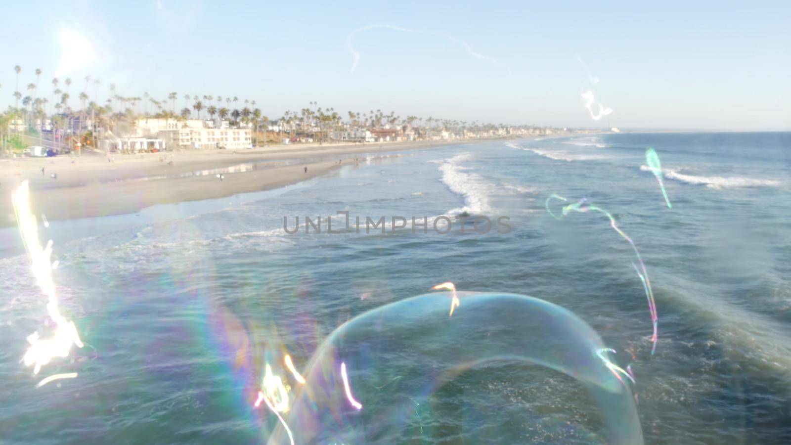 Soap bubbles on pier in California, blurred summertime seamless looped background. Creative romantic metaphor, concept of dreaming, happiness and magic. Abstract symbol of childhood, fantasy, freedom by DogoraSun