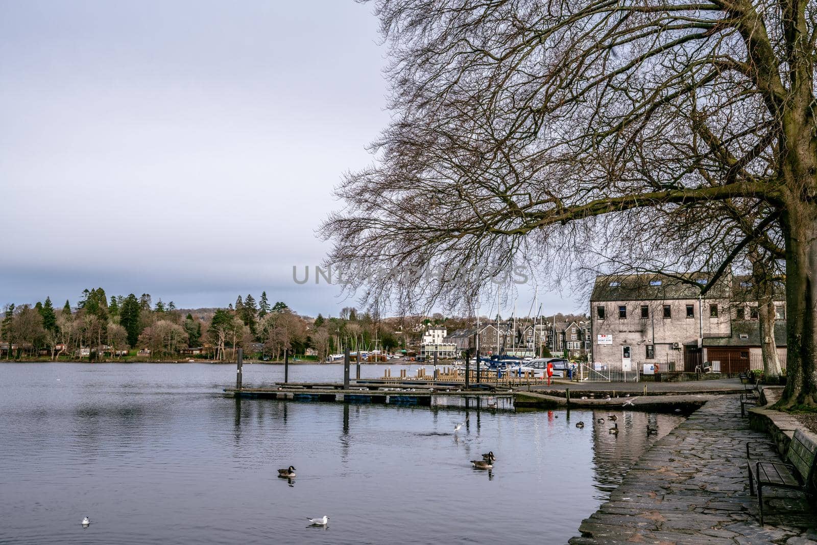 Bowness on Windermere, Cumbria, UK - February 01, 2021: Tourist pleasure boats on Bowness Bay Lake Windermere during covid lockdown by paddythegolfer