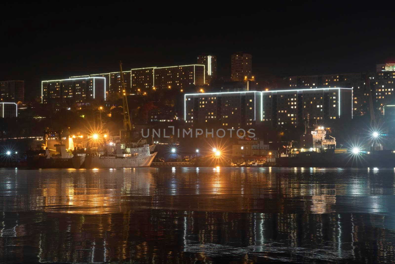 Vladivostok, Russia. Urban landscape with silhouettes of houses and light from lanterns.