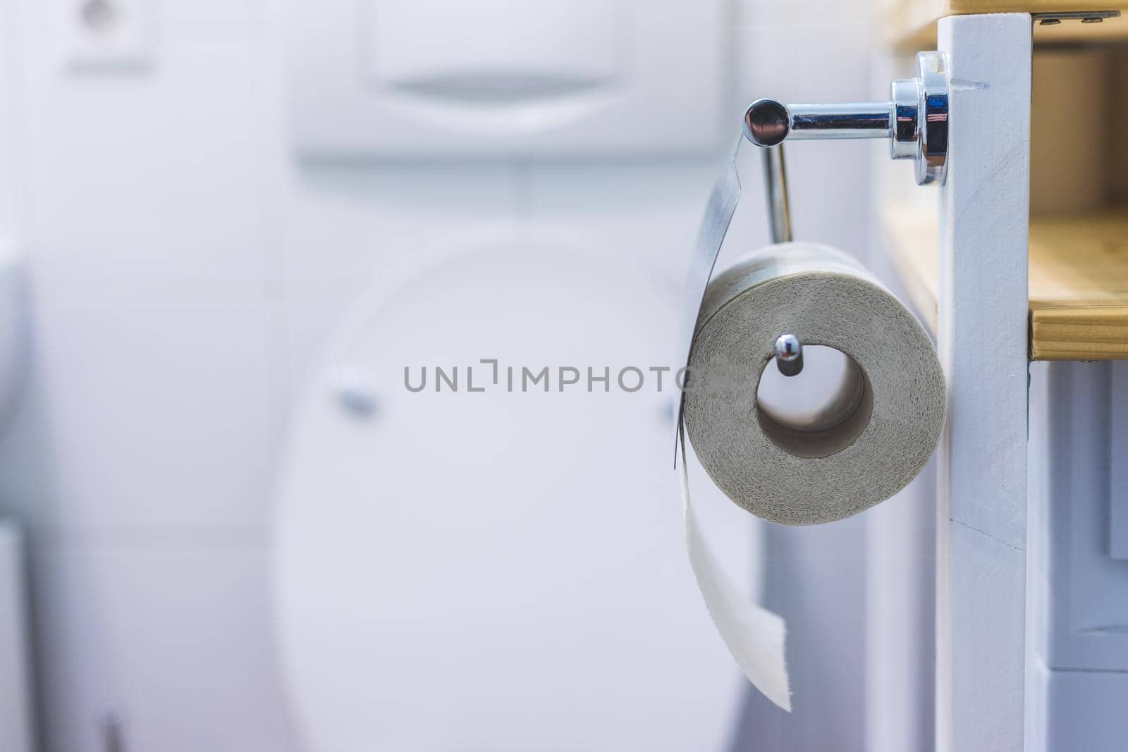 Close up of toilet paper roll on chrome hanger