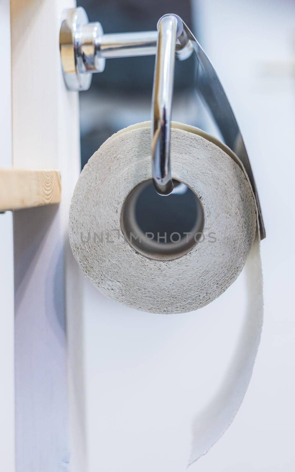 Close up of toilet paper roll on chrome hanger