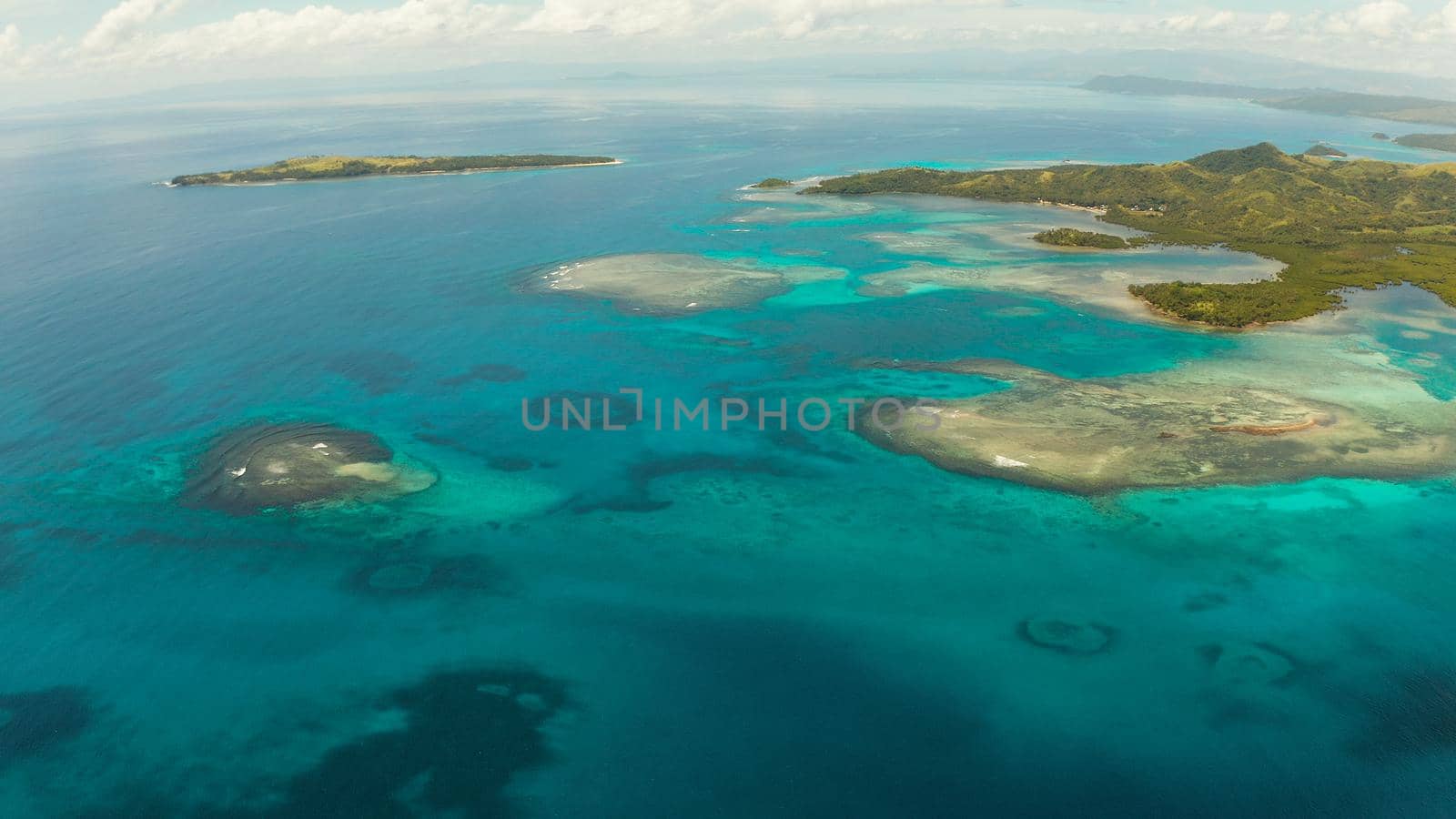 Islands are surrounded by an atoll and a coral reef with blue water top view. Bucas grande, Philippines. Summer and travel vacation concept.