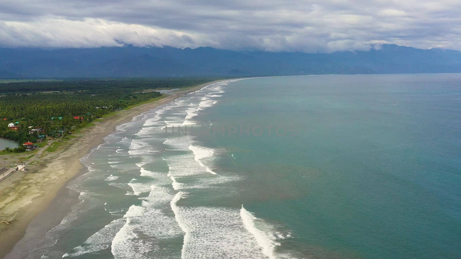 The coast with hotels and tourists, a famous place for surfing in the Philippines, top view. Secret Surf Capital Of The Philippines. Sabang Beach, Baler, Aurora, Philippines.