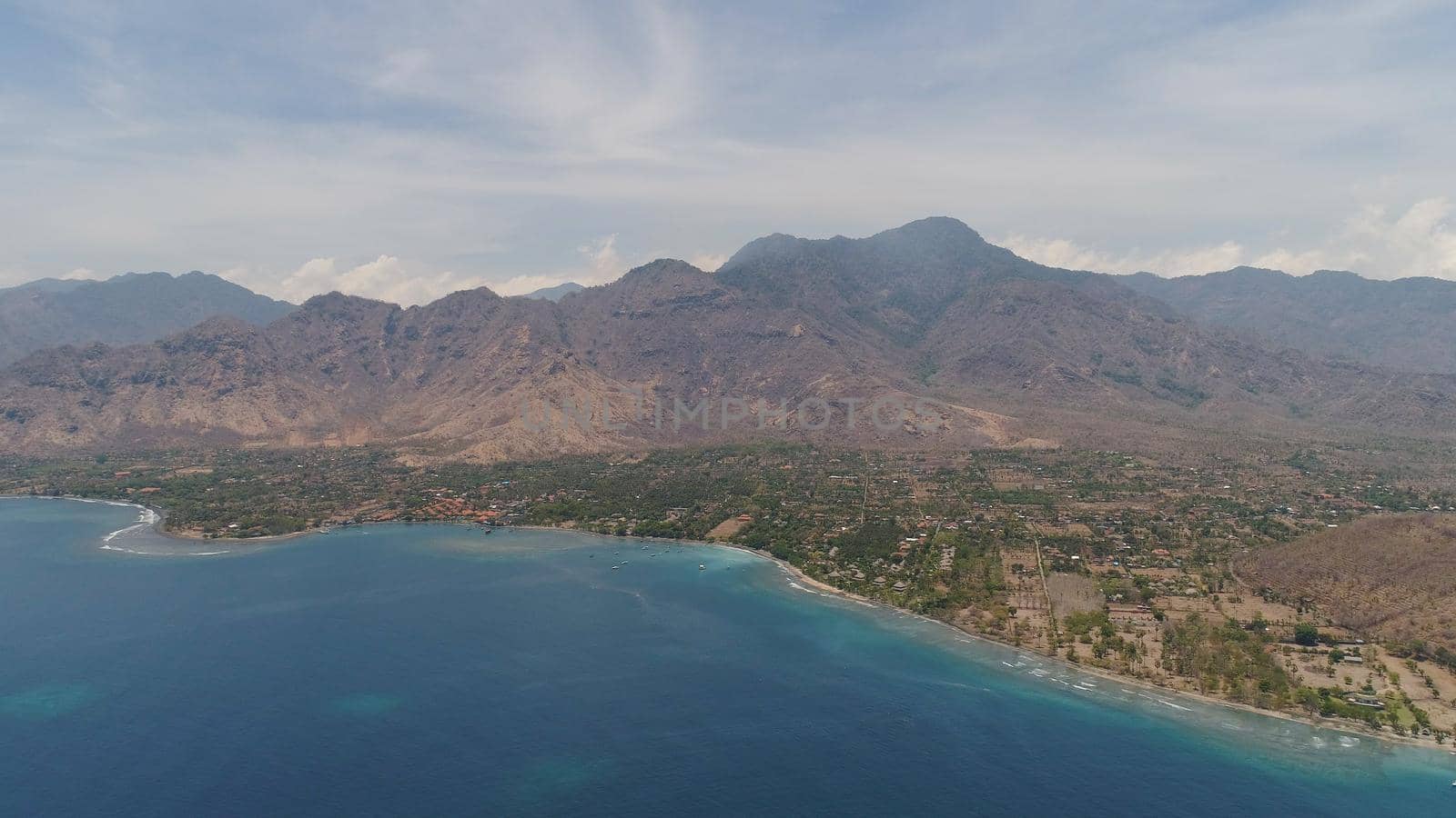 aerial tropical landscape town by sea, mountains, beach, boats on surface water. Bali,Indonesia, travel concept