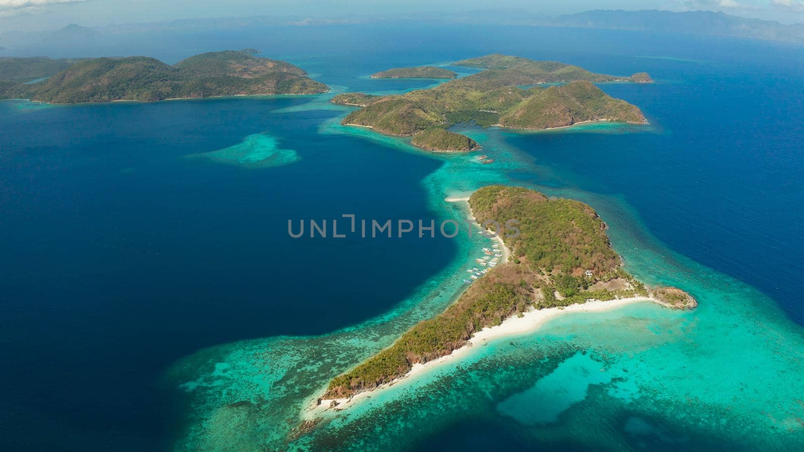 aerial view tropical islands with blue lagoons, coral reef and sandy beach. Palawan, Philippines. Islands of the Malayan archipelago with turquoise lagoons.