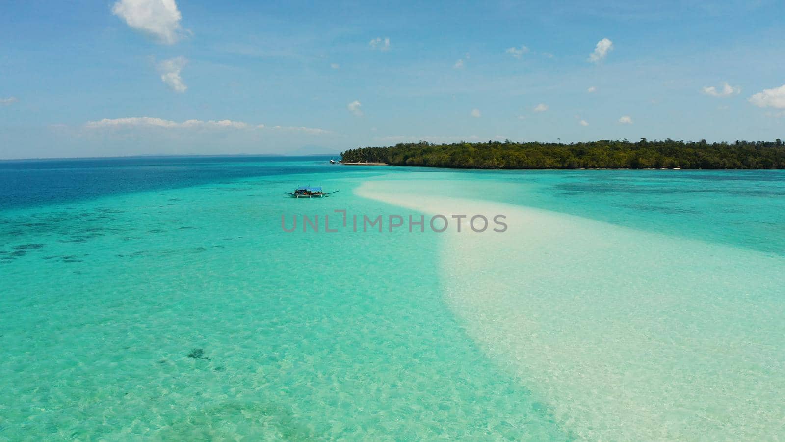 Tropical landscape with a beautiful beach in the blue water and an island with coral reef and atoll. Mansalangan sandbar, Balabac, Palawan, Philippines. Summer and travel vacation concept