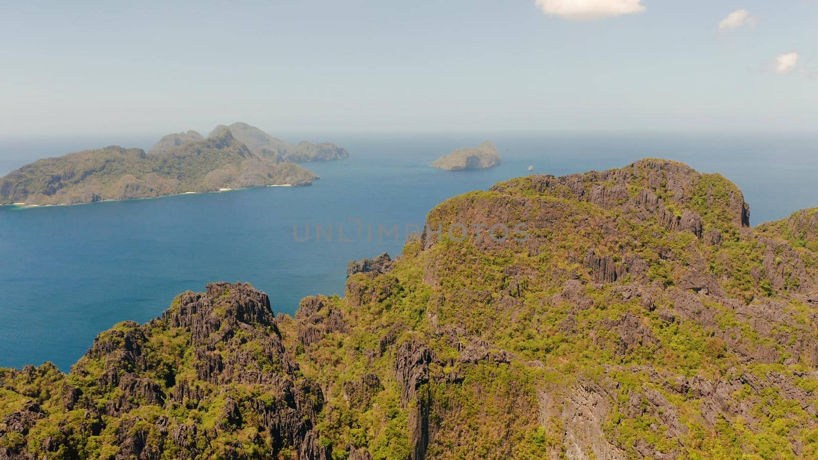 aerial view of bay and the tropical islands. Seascape with tropical rocky islands, ocean blue water. islands and mountains covered with tropical forest. El nido, Philippines, Palawan. Tropical Mountain Range