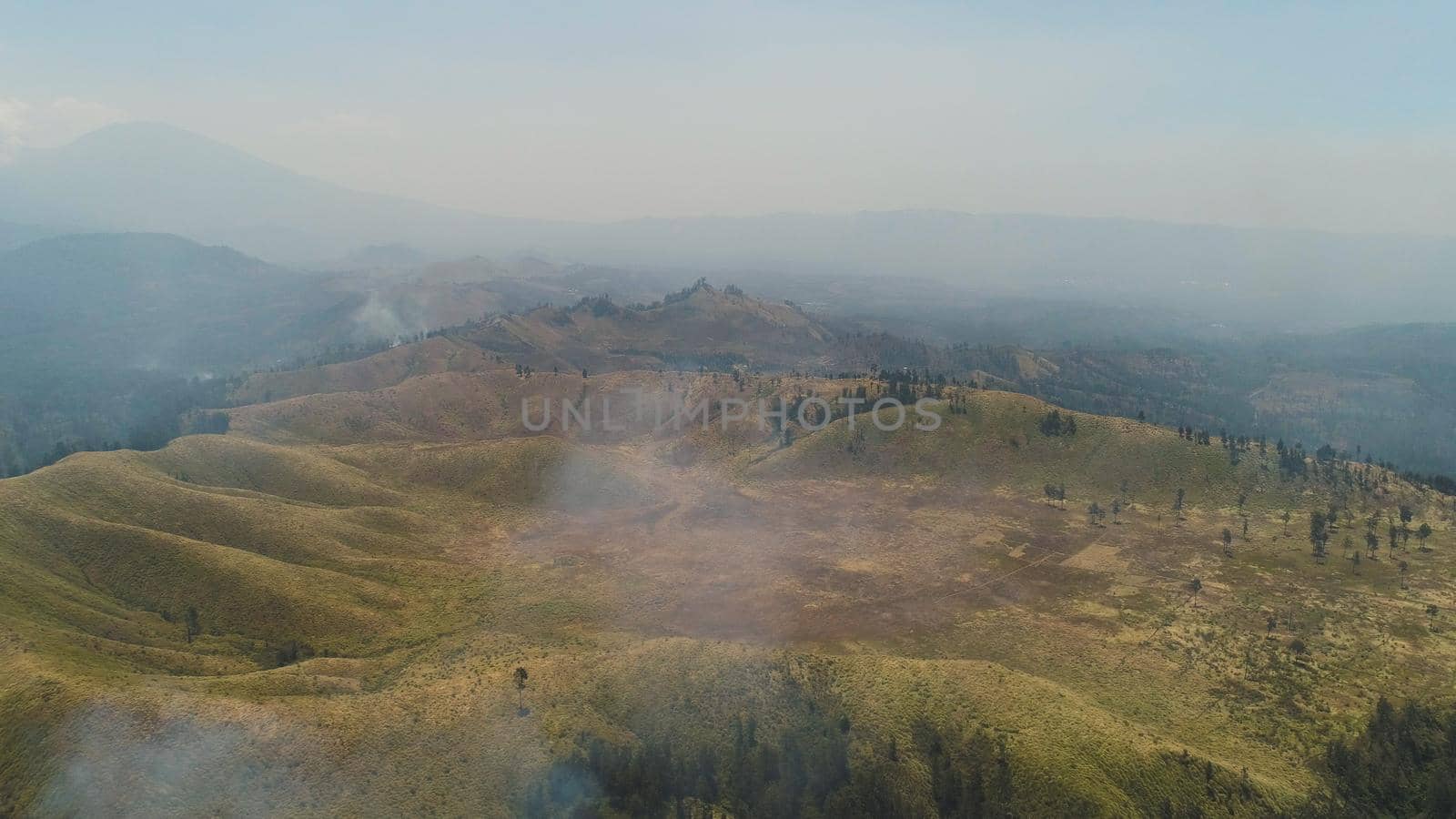 aerial view forest fire smoke on slopes hills. wild fire in tropical forest, Java Indonesia. natural disaster fire in Southeast Asia