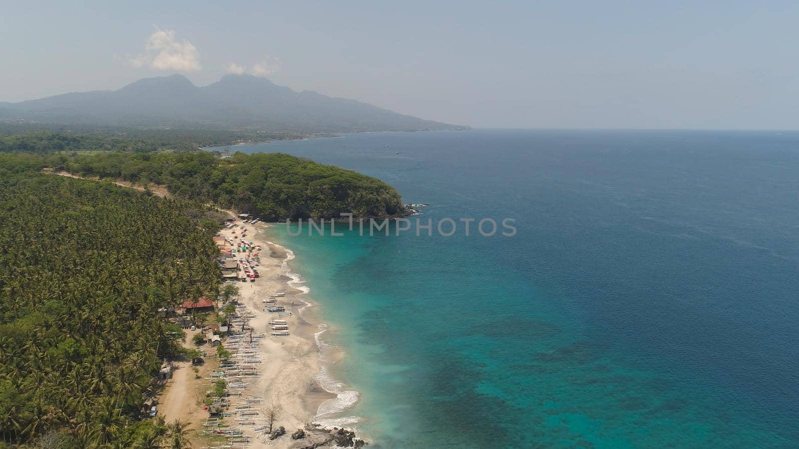 sandy beach with palm trees in tropical resort. aerial seascape sand beach with turquoise water. Seascape, ocean and beautiful beach.Travel concept. Indonesia, Bali