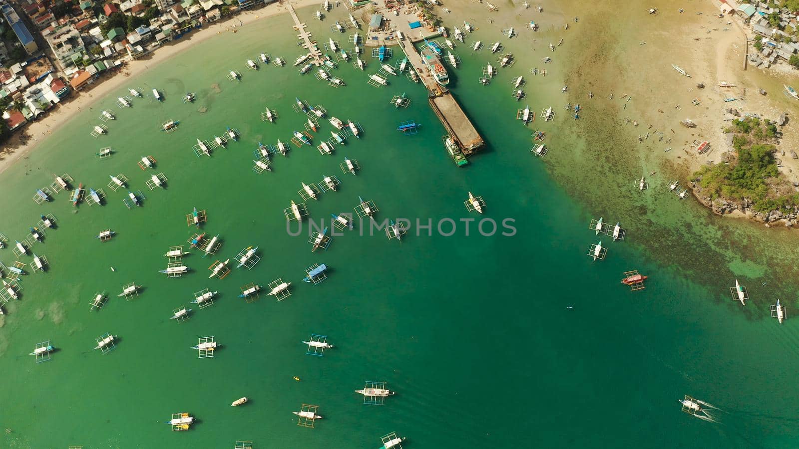 Many boats in the turquoise lagoon near city El nido. Seascape with blue bay and boats view from above. Palawan, Philippines. traditional Filipino wooden outrigger boat called a banca. Summer and travel vacation concept
