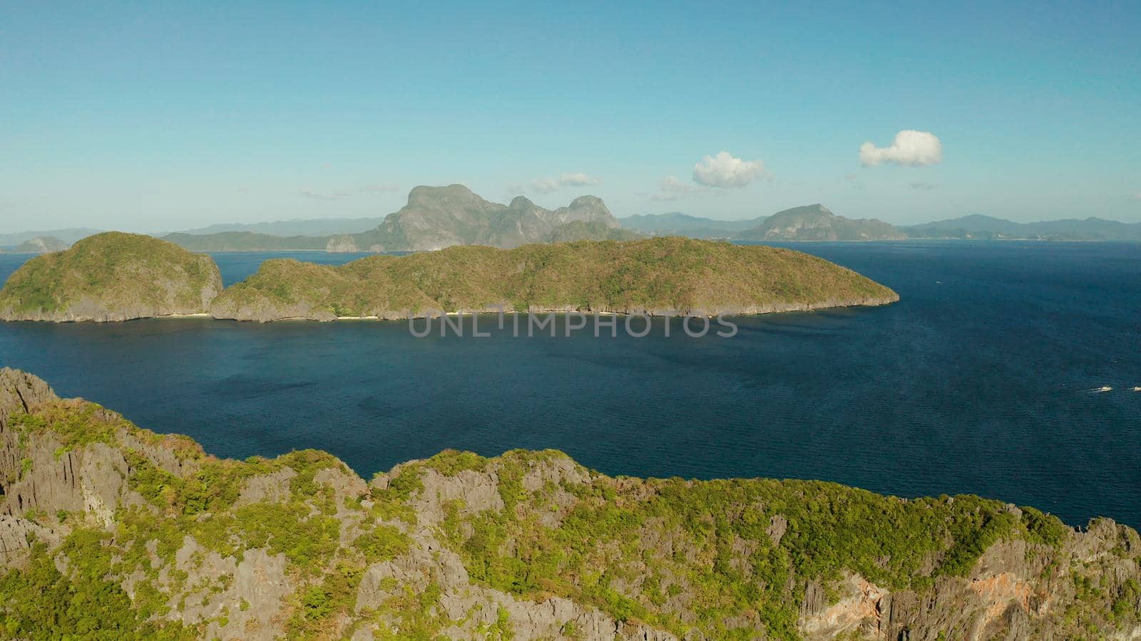 Bay and the tropical islands. Seascape with tropical rocky islands, ocean blue wate, aerial view. islands and mountains covered with tropical forest. El nido, Philippines, Palawan. Tropical Mountain Range