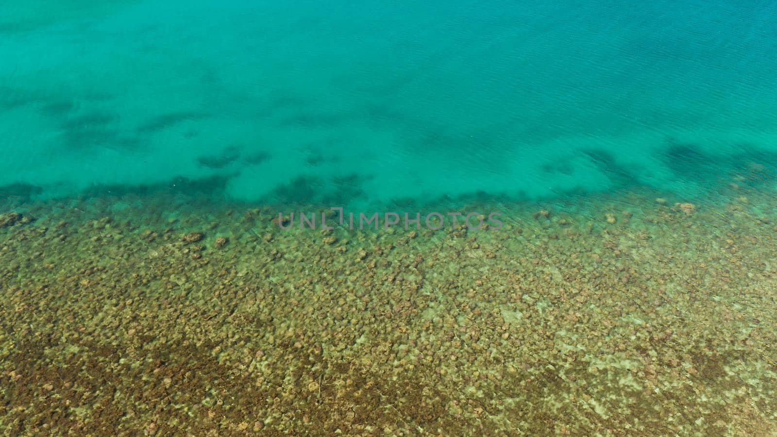 Aerial view clean sea surface copy space for text. Sea water surface in lagoon. Top view transparent turquoise ocean water surface. sea bottom with stones