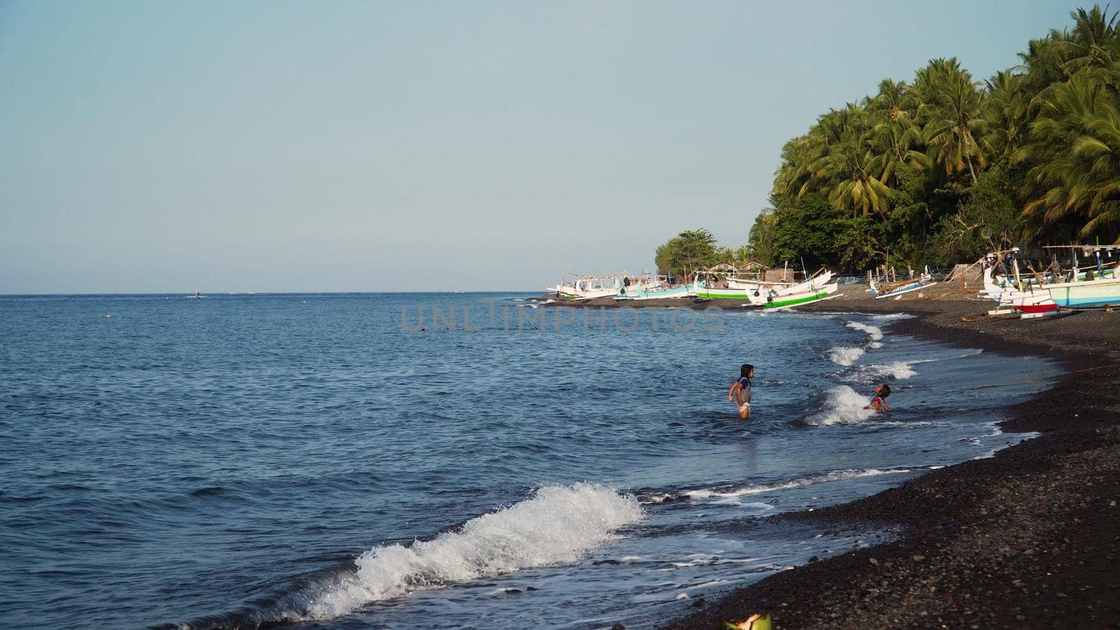Shore with beach and fishing boats. tropical landscape coastline with black volcanic sand