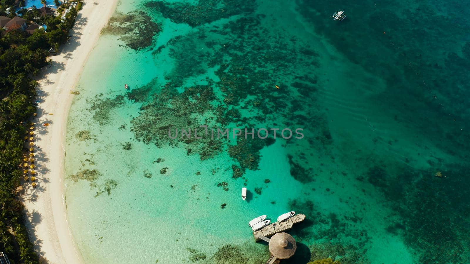 Travel concept: sandy beach and hotels near the blue lagoon, from above, Boracay, Philippines. Seascape with beach on tropical island. Summer and travel vacation concept.
