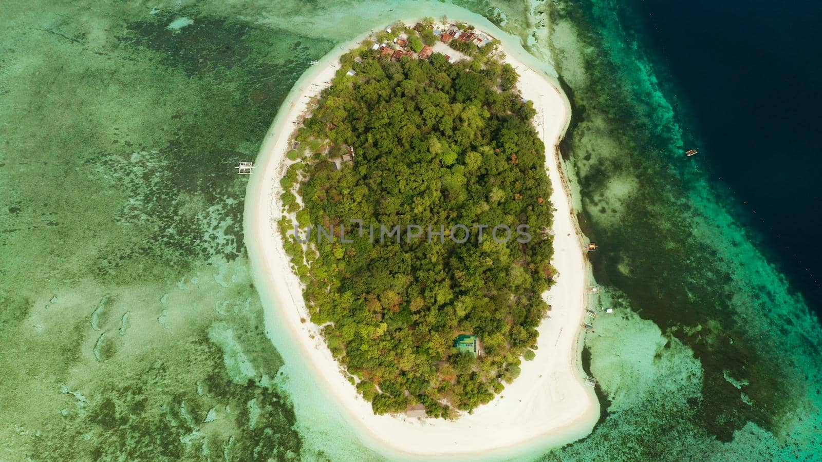 Tropical island Mantigue and sandy beach surrounded by atoll coral reef and blue sea, aerial view. Small island with sandy beach. Summer and travel vacation concept, Camiguin Philippines Mindanao