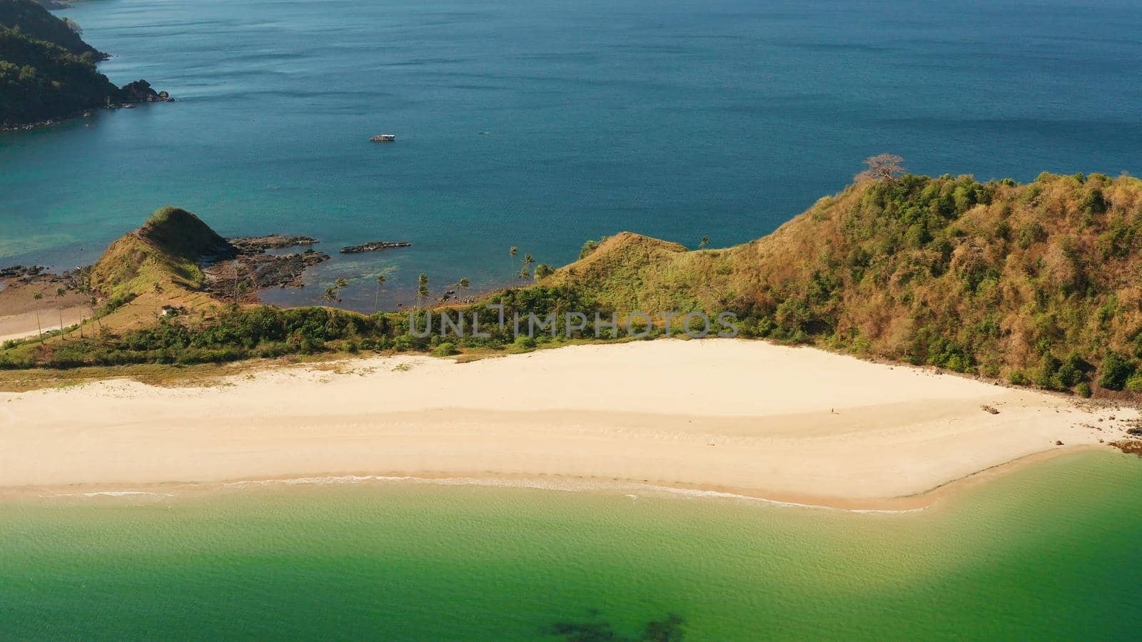 Blue sea and tropical beach, aerial drone. Nacpan, El Nido, Palawan, Philippine Islands. Seascape with tropical beach and islands. Summer and travel vacation concept