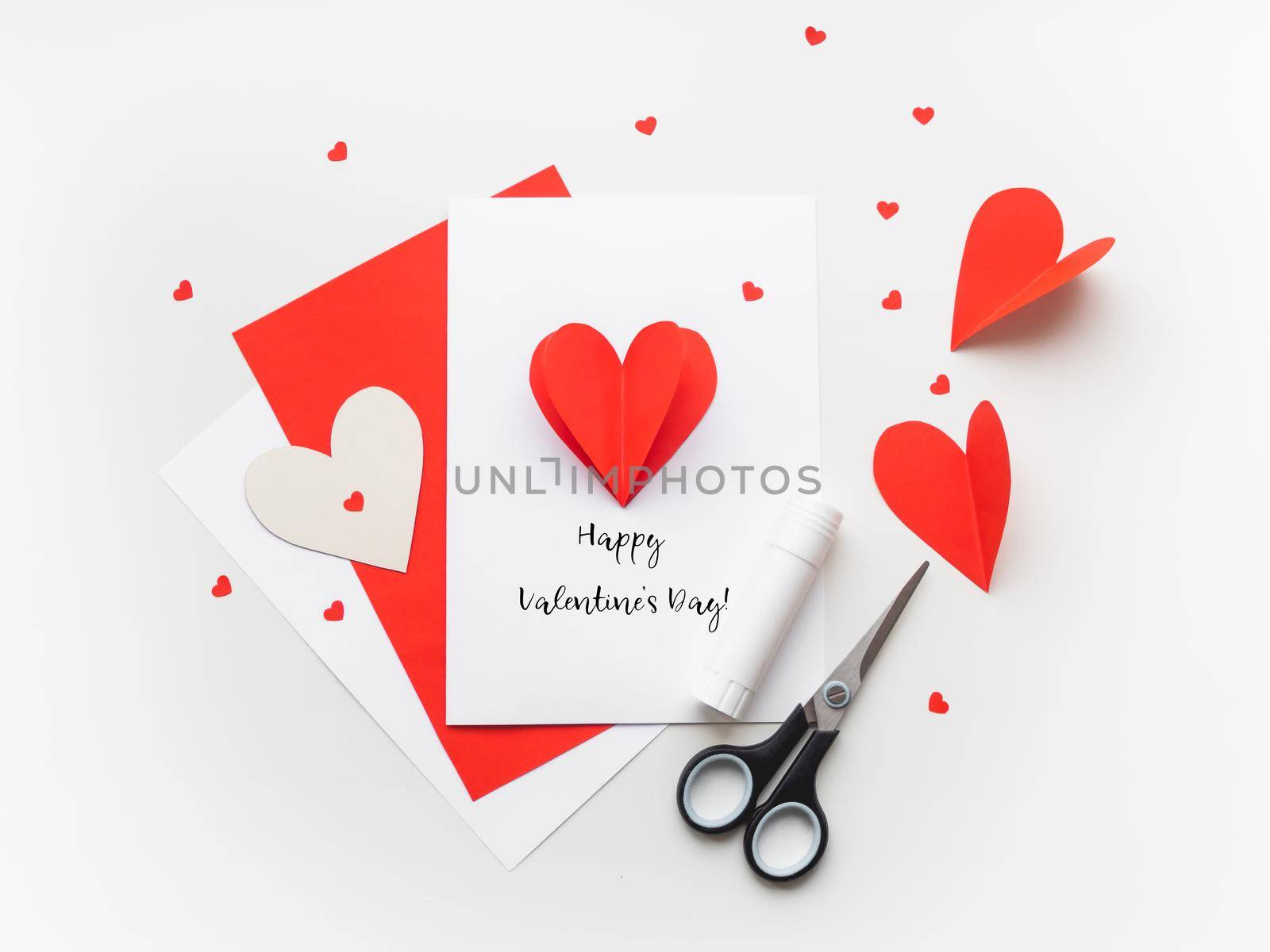 Valentine's Day greeting card. DIY holiday card with red paper volumetric heart, symbol of love and romance. Handmade card made with scissors, glue and colored paper. by aksenovko