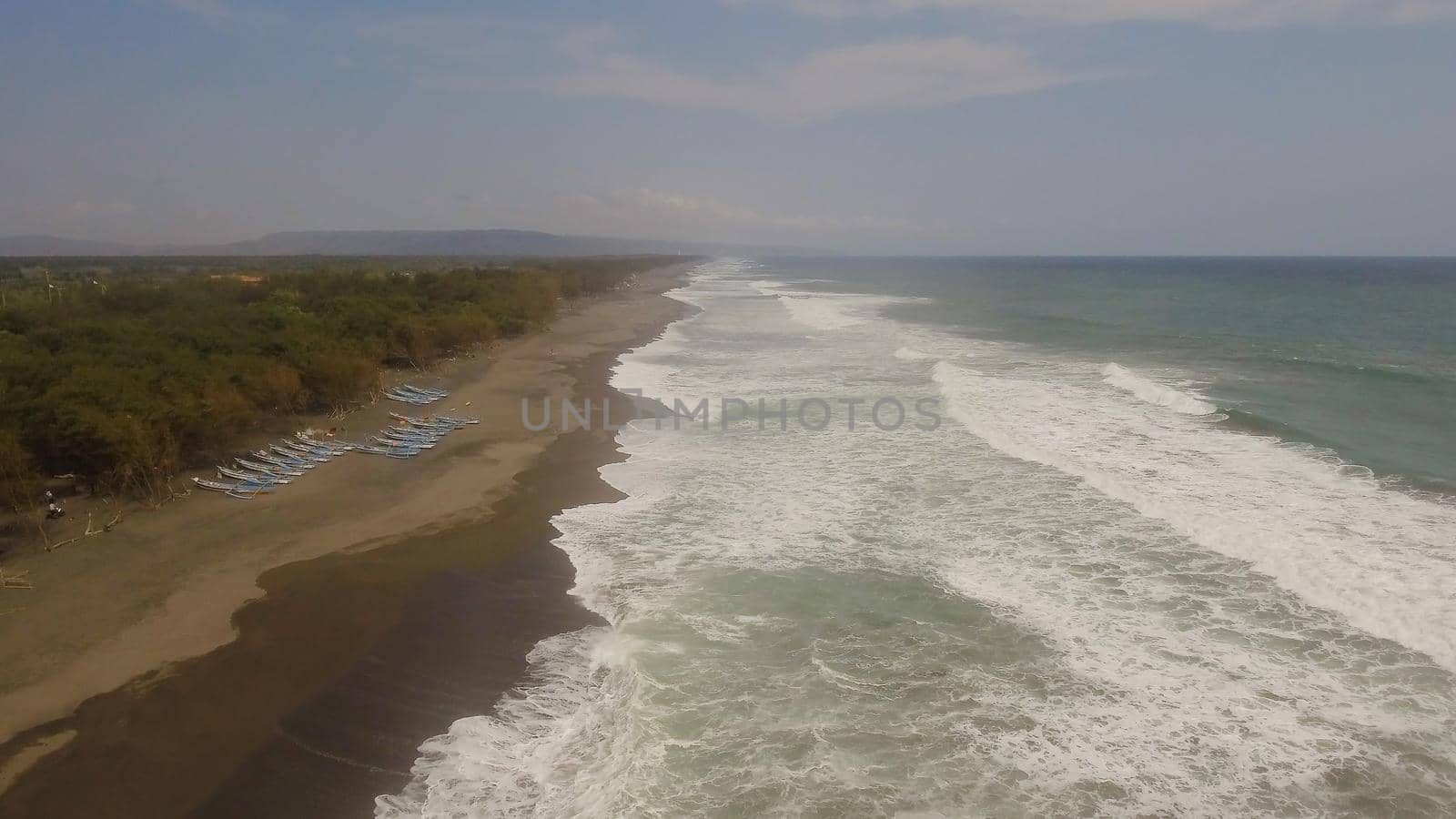 aerial view sandy beach near ocean with big waves at sunset time in tropical resort, Yogyakarta, Indonesia. seascape, ocean and beautiful beach. Travel concept. Indonesia, java