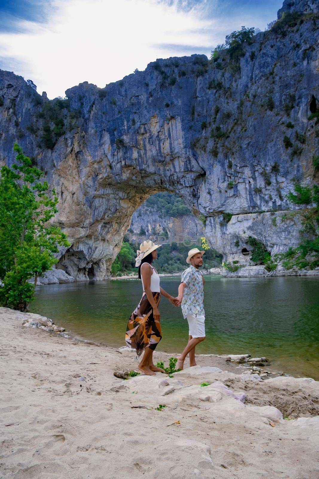 couple men and woman visiting The famous natural bridge of Pont d'Arc in Ardeche department in France Ardeche. Europe Rhone Alpes
