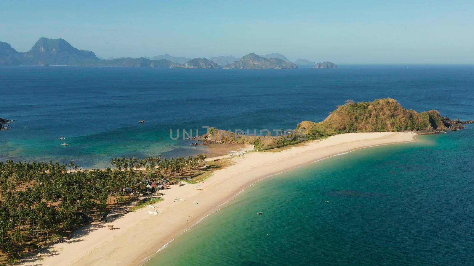 Blue sea and tropical beach, aerial drone. Nacpan, El Nido, Palawan, Philippine Islands. Seascape with tropical beach and islands. Summer and travel vacation concept