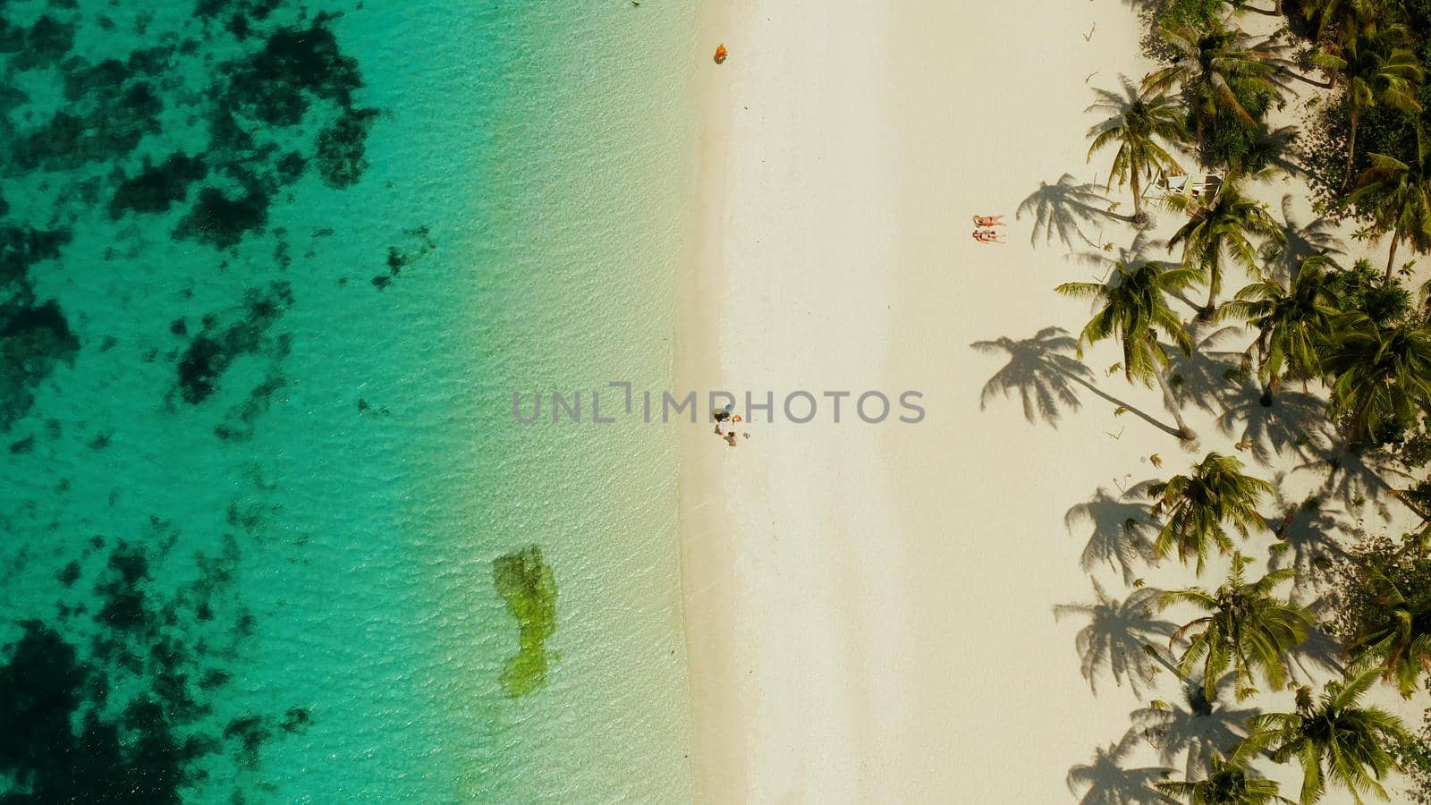 Travel concept: sand beach with tourists and turquoise water on Boracay, Philippines, aerial drone. Seascape with Puka shell beach on tropical island. Summer and travel vacation concept.