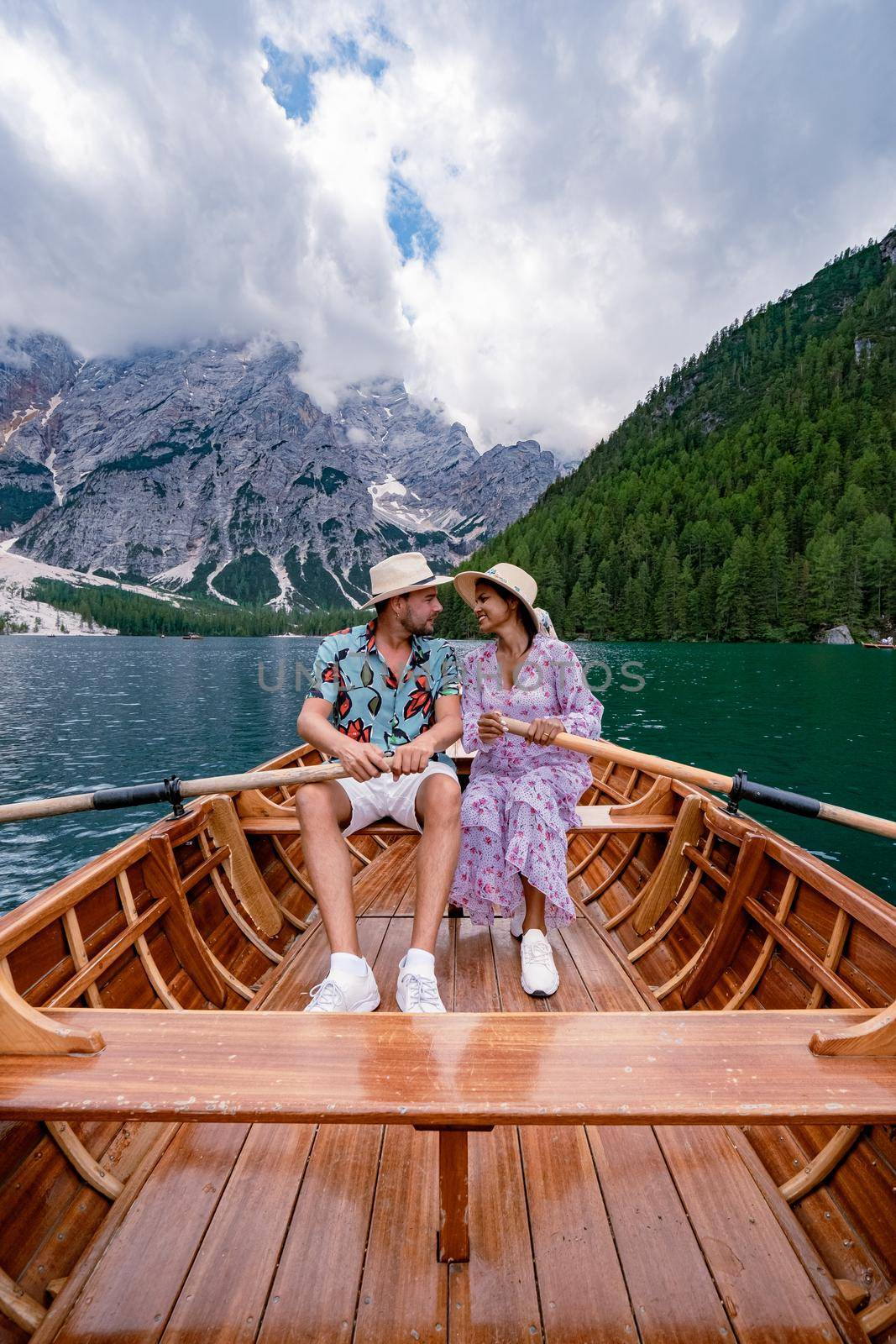 Beautiful lake in the Italian Alps, Lago di Braies in the Italian Dolomites Europe. Braies lake, Italy. The famous lake in the Dolomites, a couple of men and woman mid-age visit Prager wildsee rowing boat