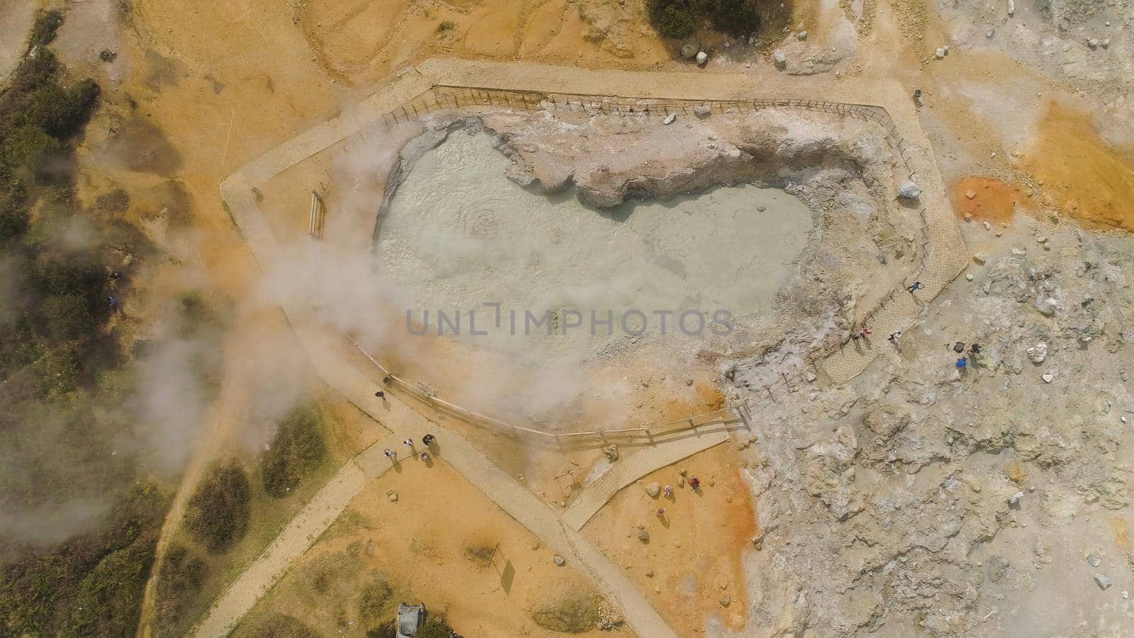 plateau with volcanic activity, mud volcano Kawah Sikidang, geothermal activity and geysers. aerial view volcanic landscape Dieng Plateau, Indonesia. Famous tourist destination of Sikidang Crater it still generates thick sulfur fumes.