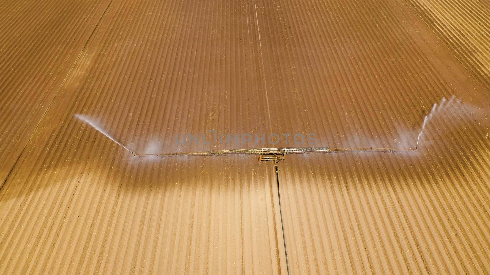 aerial view Center pivot agriculture irrigation machine of crops. An irrigation pivot watering agricultural land. Irrigation system watering farm land.