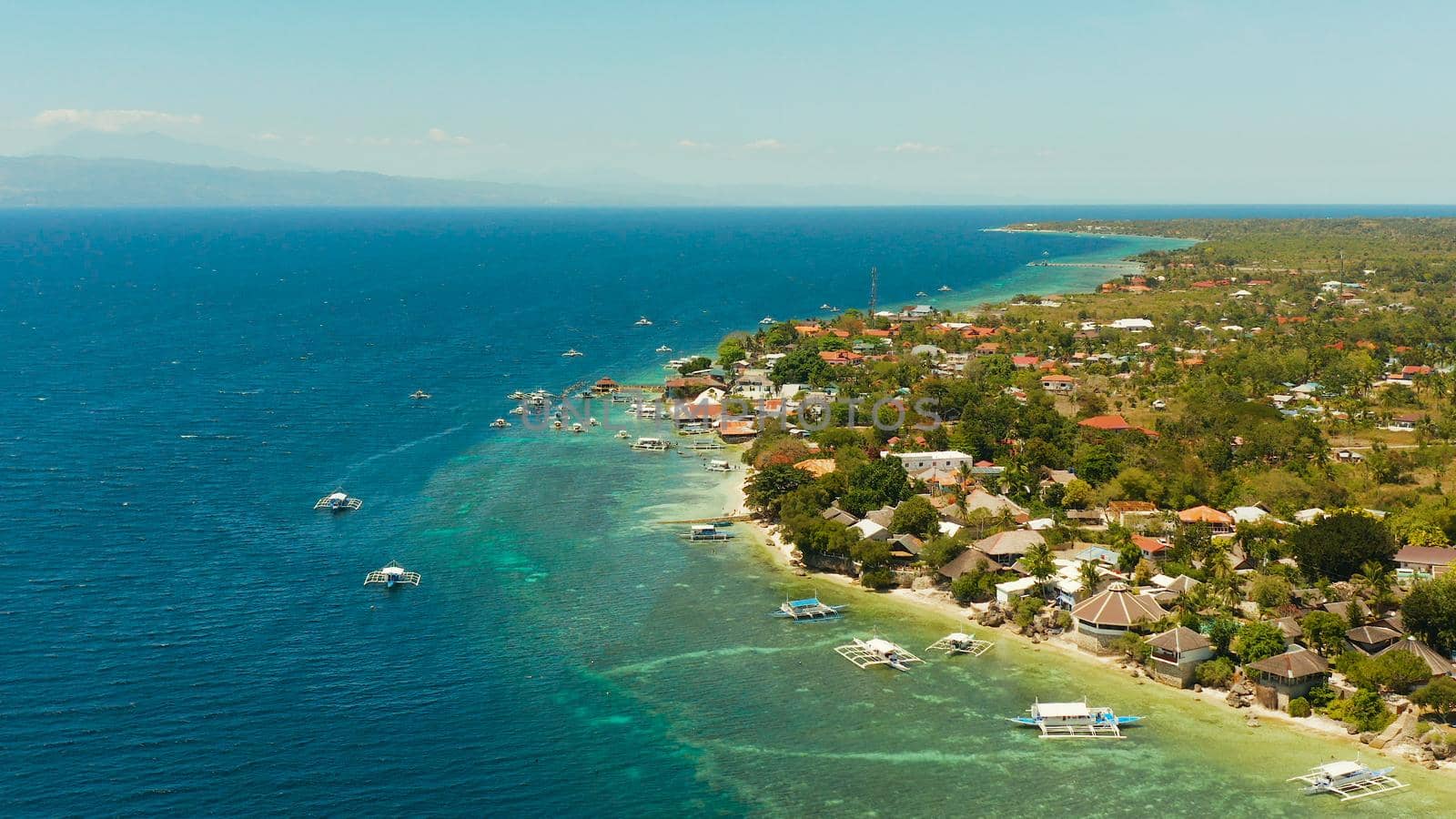 Coral reef and turquoise water with Philippine boats in the famous diving spot of Moalboal, Cebu. Aerial view, Summer and travel vacation concept