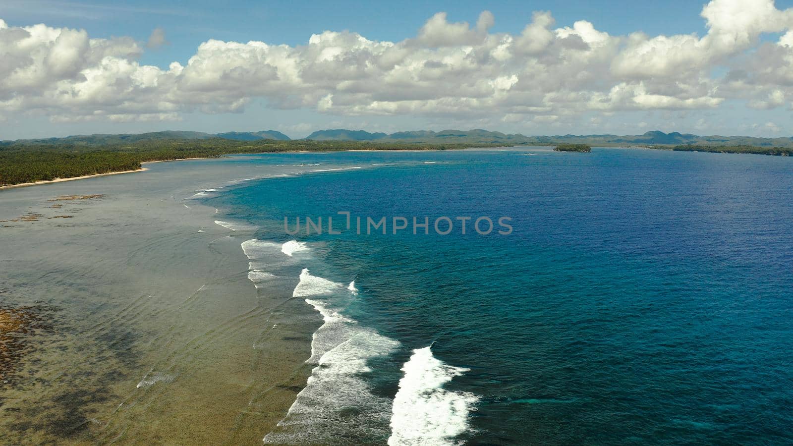 Tropical island with forest and ocean with surf and coral reef top view. Summer and travel vacation concept